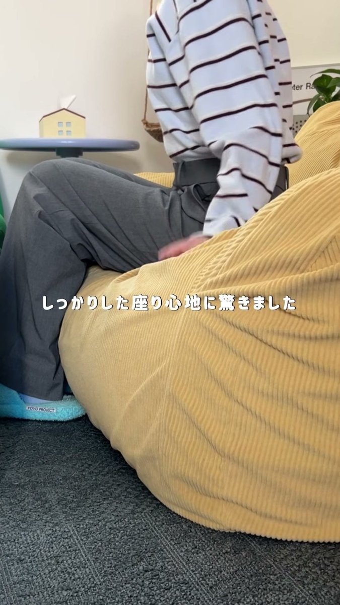 黄色のLOOSYに腰を下ろした横向きの姿