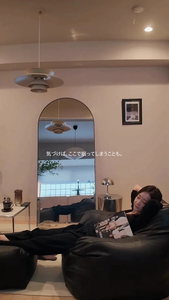 ソファで本を膝に置いて休む人